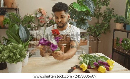 African american man uses smartphone to photograph plants inside a flower shop.
