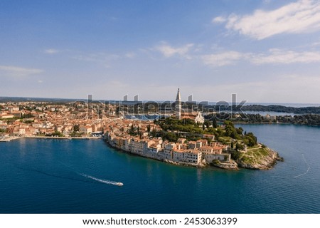 Rovinj, Croatia: Boat sailing around the Rovinj medieval old town with its Venetian campanile in Istria by the Adriatic sea in Croatia Royalty-Free Stock Photo #2453063399