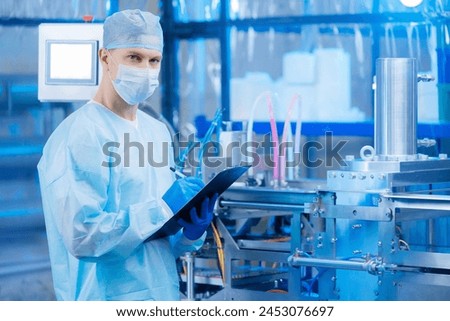 Worker use clipboard for control quality on automatic machine production line for manufacture of medical plastic form for surgical kit. Concept med industry on medicine factory Royalty-Free Stock Photo #2453076697