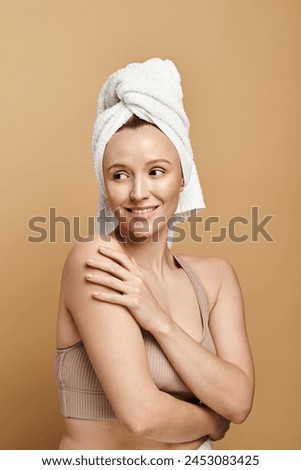 A naturally beautiful woman poses gracefully with a towel wrapped around her head. Royalty-Free Stock Photo #2453083425