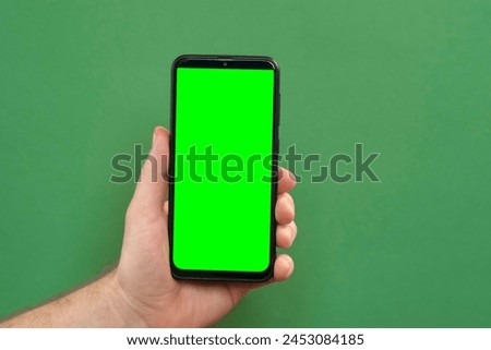 Young man hand use smartphone with green screen on green background. Gestures pack. Male hand touching, clicking, tapping swiping on black phone chromakey display. Close up Device. Modern Technology