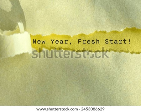 New Year fresh start text behind torn paper background. Stock photo.