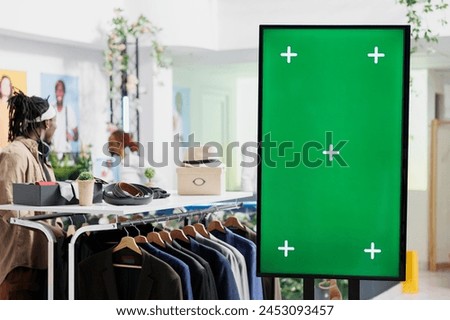 Digital board with green screen for clothes brand promotion mock up in shopping center. Smart display with chroma key for apparel new collection advertisement in fashion boutique