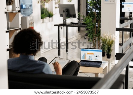 Arab businessman analyzing financial data on laptop screen in startup office. Executive manager comparing sales metrics and checking investment revenue statistics in coworking space Royalty-Free Stock Photo #2453093567