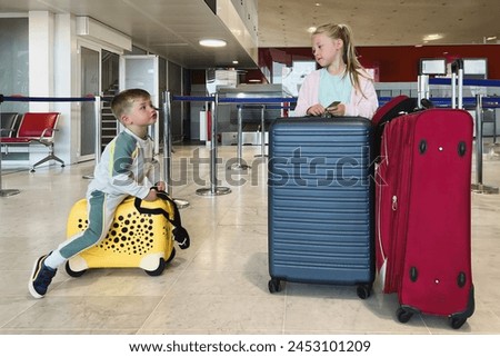 Children in the waiting room on suitcases flying to Paris at summer Royalty-Free Stock Photo #2453101209