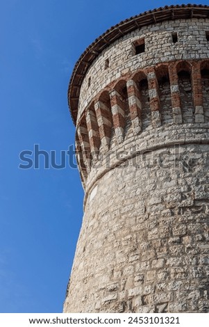 The vertical perspective highlights the majestic Torre dei Prigionieri, part of Brescia castle, with its stone masonry and medieval battlements Royalty-Free Stock Photo #2453101321