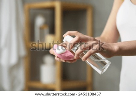 Washing face. Woman applying cleansing foam onto brush in bathroom, closeup. Space for text