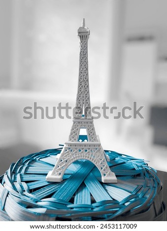 Miniature Icon: Featured Toy Eiffel Tower, white tower, photograph of a small tower, Paris, miniature, blue, blurred background, photograph 