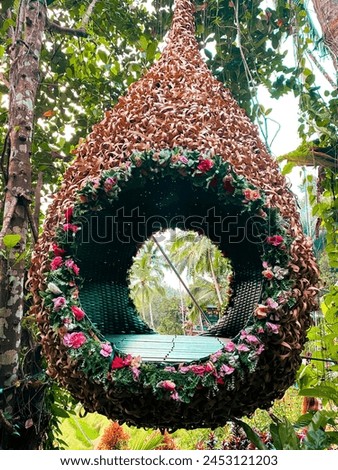 The photo spot consists of a seat made of rattan surrounded by plants and flowers