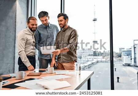 A team of different businessmen colleagues are standing in an office with panoramic windows, holding documents and discussing work issues. Copy space.