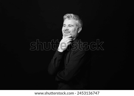 Portrait of smiling man on dark background. Black and white effect
