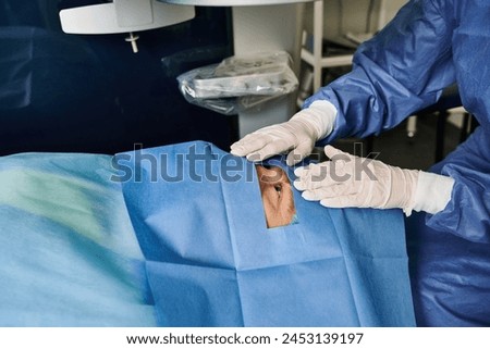 A person in a hospital room wearing gloves.
