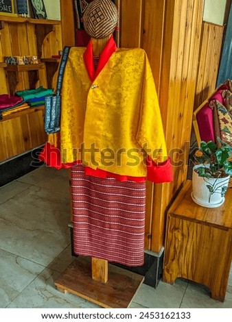 Bhutanese men's traditional dress, the gho, is a knee-length robe secured with a belt, symbolizing cultural pride and reflecting the nation's rich heritage. Royalty-Free Stock Photo #2453162133