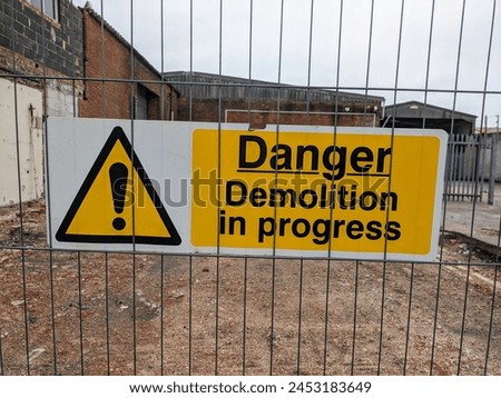 Danger sign Demolition in progress. fenced off site undergoing demolition work