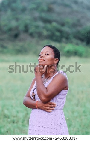 Black woman, from the Northeast representing the Northeast of Brazil. she is in a natural environment, contemplating nature and giving thanks. Royalty-Free Stock Photo #2453208017