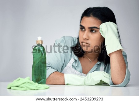 Frustrated, woman and thinking about cleaning with gloves, detergent and cloth for house chores in studio. Depressed, female person and spray bottle with chemicals from anxiety for bacteria and germs