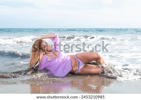 beautiful blonde girl with long curly hair on a beach