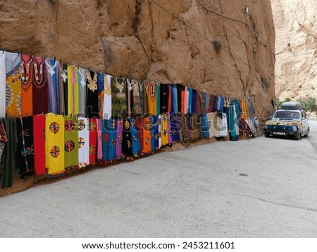 On the way to the Upper Todgha Gorges in Tinerhir, there are valleys, trees, and winding roads. In the straits, many traditional clothes, jewelry, natural stones, and fossils are sold. Royalty-Free Stock Photo #2453211601
