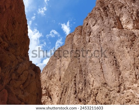 On the way to the Upper Todgha Gorges in Tinerhir, there are valleys, trees, and winding roads. In the straits, many traditional clothes, jewelry, natural stones, and fossils are sold. Royalty-Free Stock Photo #2453211603