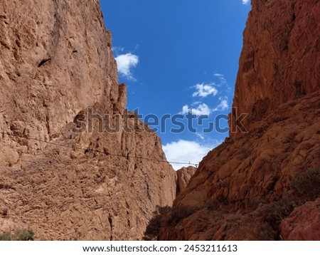 On the way to the Upper Todgha Gorges in Tinerhir, there are valleys, trees, and winding roads. In the straits, many traditional clothes, jewelry, natural stones, and fossils are sold. Royalty-Free Stock Photo #2453211613