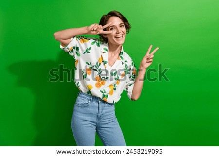 Photo of sweet pretty girl dressed print shirt showing v-sign cover eye isolated green color background