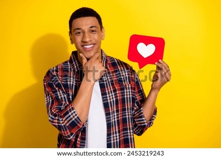Photo of attractive popular blogger nice man wear stylish plaid clothes hand hold red paper card like isolated on yellow color background