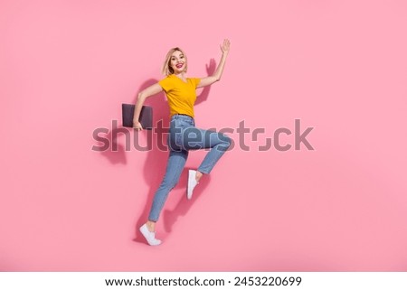 Full length photo of funky funny lady dressed yellow t-shirt jumping hurying holding modern gadget isolated pink color background