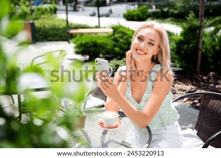 Photo of gorgeous pretty cheerful girl holding phone chatting enjoying relax rest vacation weekend breakfast coffee time spring sunny day