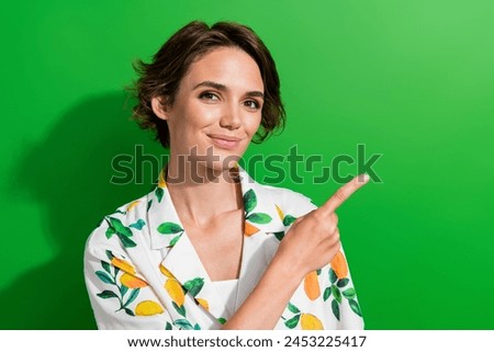 Photo of adorable sweet lady wear print shirt pointing finger empty space isolated green color background