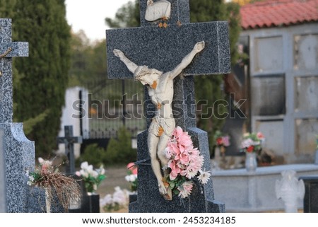 Cemeteries often have statues or other religious iconography to provide comfort and hope to visitors.  The statue of Jesus on the cross is a common symbol in Christianity and represents Jesus’ sacrifi Royalty-Free Stock Photo #2453234185