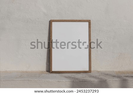Minimal empty vertical wooden frame picture mockup against white old textured white wall in sunlight. A4, A3, A2 poster template, neutral Summer background with light, shadows. Mediterranean design.