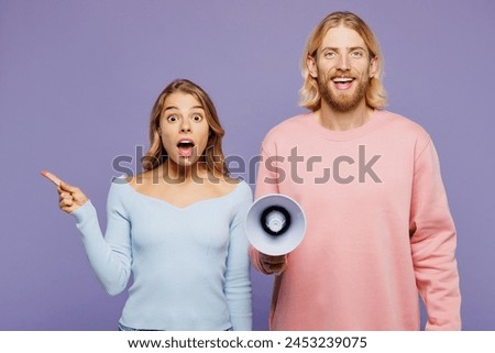 Young couple two friends family man woman wear pink blue casual clothes together hold megaphone scream announces discounts sale Hurry up point finger aside isolated on pastel plain purple background