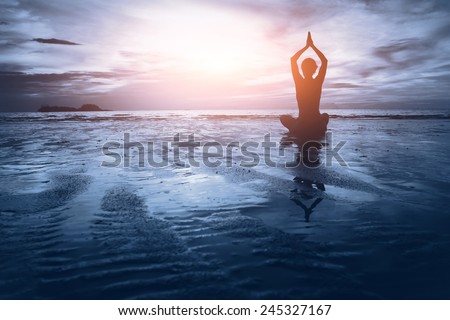 well being concept, beautiful sunset on the beach, woman practicing yoga Royalty-Free Stock Photo #245327167