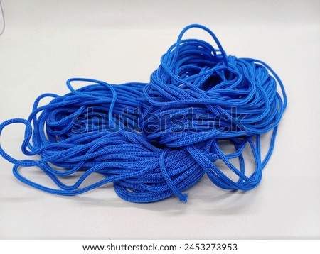 Blue Kur rope isolated on white background. Kur rope (Tali Kur) is a type of rope made from fibers, both natural and synthetic. Royalty-Free Stock Photo #2453273953