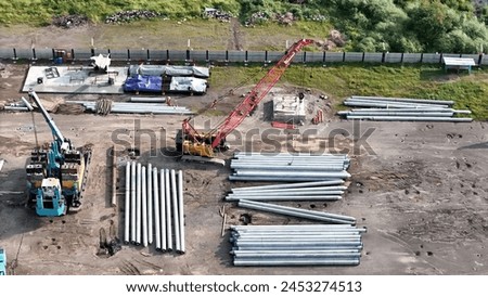 aerial view of construction site, spun piles, tractors, pulleys and large construction equipment. Royalty-Free Stock Photo #2453274513