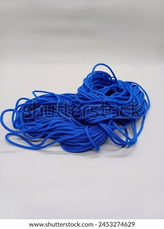 Blue leather strap isolated on white background. Kur Rope (Tali Kur) is a type of rope made from both natural and synthetic fiber materials. Photos are taken in portrait. Royalty-Free Stock Photo #2453274629