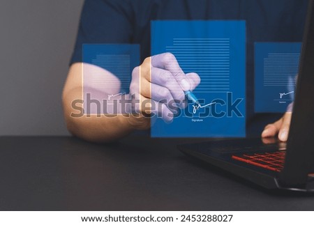 Signature Electronic. A businessman uses a pen to sign electronic documents on a virtual screen while sitting at a desk in the office. The concept of a paperless office Royalty-Free Stock Photo #2453288027