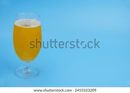 Vitamin C effervescent pill dissolved in glass of water on blue background. Copy space for text.