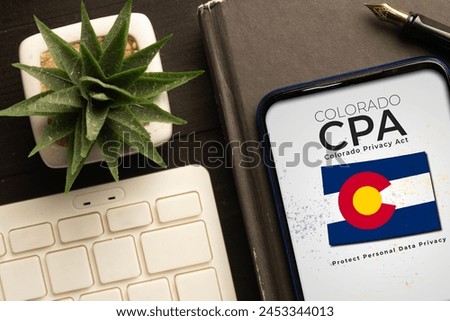 CPA (Colorado Privacy Act) concept: smartphone over a book on a wooden table