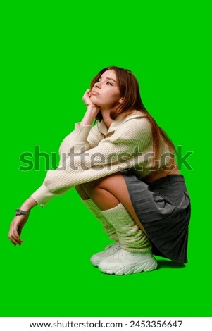Woman Sitting on Ground in Front of Green Screen
