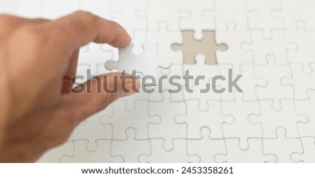hand holding final puzzle and success, business success concept Royalty-Free Stock Photo #2453358261