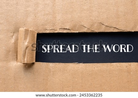 Spread the word written on ripped cardboard paper with black background. Conceptual spread the word symbol. Copy space.