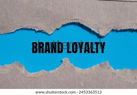 Brand loyalty words written on ripped paper with blue background. Conceptual brand loyalty symbol. Copy space.