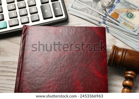 Tax. Book, dollar banknotes, gavel and calculator on wooden table, above view