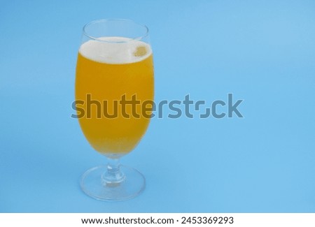 Glass of water with dissolved vitamin C effervescent tablet on blue background. Copy space for text.