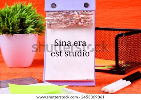 Sina era est studio It means Without anger and addiction It is written on a desktop calendar with loose leaves