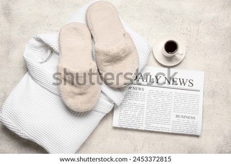 White slippers with cup of coffee, bathrobe and newspaper on white grunge background. Top view