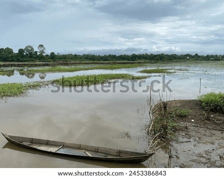 Rural areas in South Kalimantan. April 21, 2024. Old traditional wooden boat in village rice fields. Photo taken from a height. Royalty-Free Stock Photo #2453386843