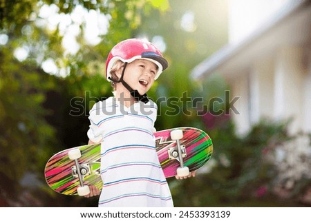 Kid with skateboard. Child riding skate board. Healthy sport and outdoor activity for school kids in summer. Sports fun. Helmet for safe exercise. Boy skater in sunny park. Children training.