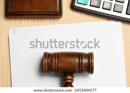 Tax law. Paper sheets, gavel and calculator on wooden table, flat lay